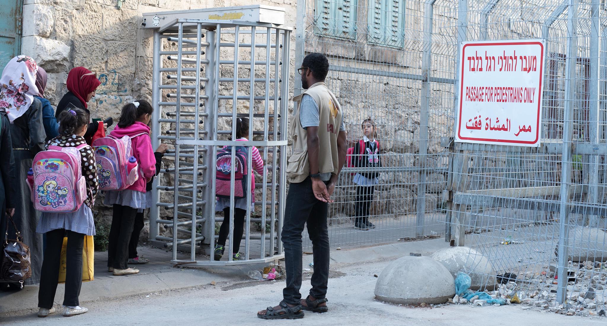Foto: Mads Gram. Skolebørn på vej gennem checkpoint i Hebron. ISM aktivist er til stede for at sikre, børnene kommer sikkert frem.
